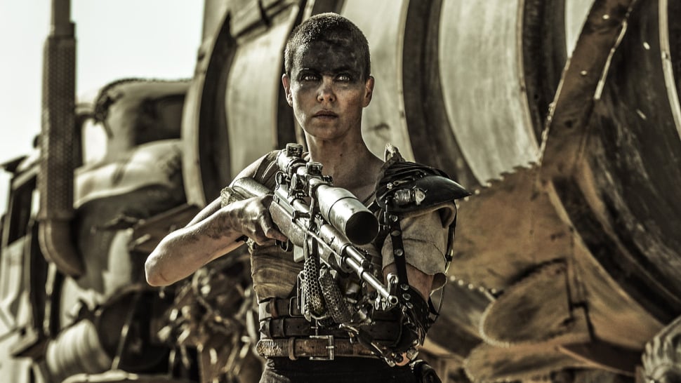Charlize Theron mit großer Waffe vor dystopischem Hintergrund.